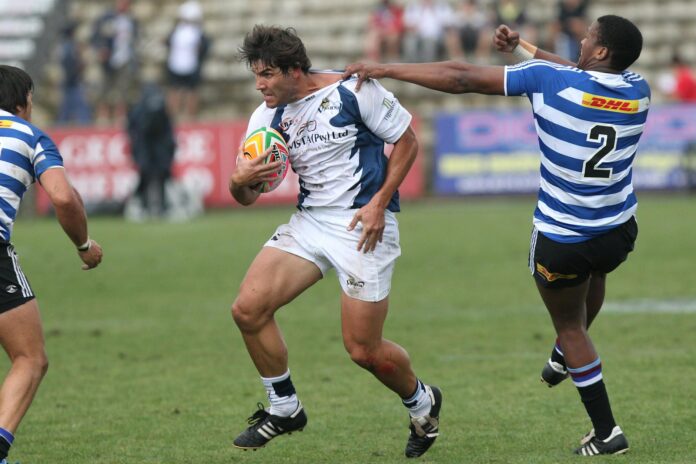 Rugby players in motion during a competitive game on a grassy field.